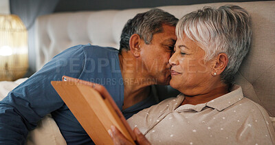 Buy stock photo Love, senior couple and kiss in bed for connection, commitment and healthy relationship in home. Retirement, man and woman in bedroom for romance, affection and loyalty to partner on tablet at night