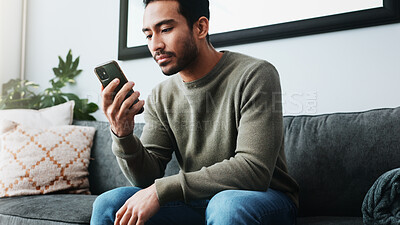 Buy stock photo Man, phone and relax with texting on sofa, home and check notification for web chat in living room. Person, smartphone and scroll on mobile app, search or contact on social network in lounge at house