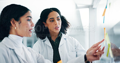 Buy stock photo Lab, scientist and women with medical research, talking and colleagues with sticky notes for information. Brainstorming, ideas and teamwork for healthcare in clinic, pharmaceutical and plan for cure