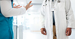 Hands, healthcare and doctors in hallway, conversation and feedback for intern. Gossip, medical service and people in hospital, performance review and closeup with discussion, diagnosis or advice