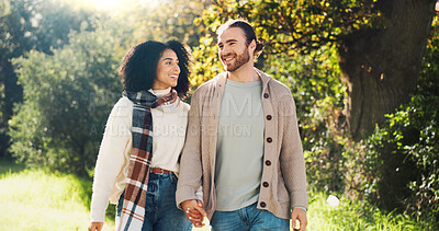 Buy stock photo Outdoor, holding hands and couple on walk, nature and people with smile on date, romance and break. Park, man and woman in relationship, love and happy for interracial marriage, travel or together