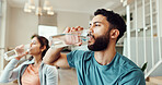 Break, drinking water and fitness with couple in living room of home for bonding, health or wellness together. Exercise, hydration or thirsty with man and woman in apartment for balance or relax