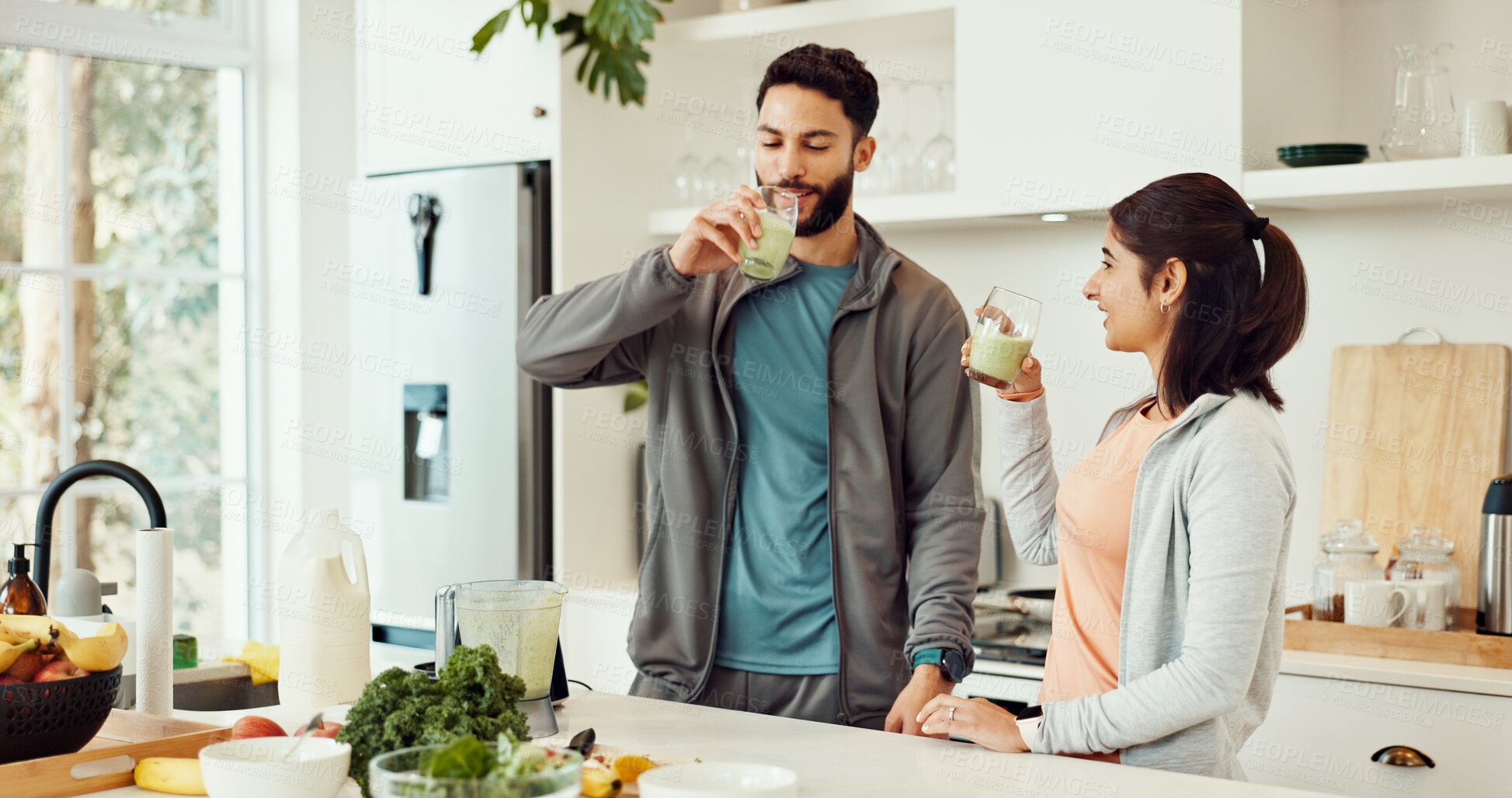 Buy stock photo Drinking, health and couple with smoothie in kitchen at home for wellness, diet and nutrition snack. Love, happy and man with woman enjoying green juice for vitamins or hydration breakfast in house.