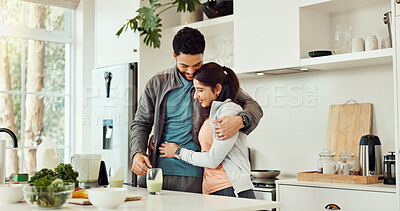 Buy stock photo Hug, health and couple with smoothie in kitchen at home for wellness, diet and nutrition snack. Love, happy and man embracing woman for thank you with green juice for vitamins or hydration in house.