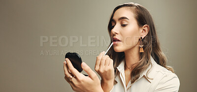 Buy stock photo Businesswoman, lipstick and mirror in studio for beauty, cosmetics and vanity. Professional person, lip gloss and makeup on gray background space for dermatology, color application and reflection