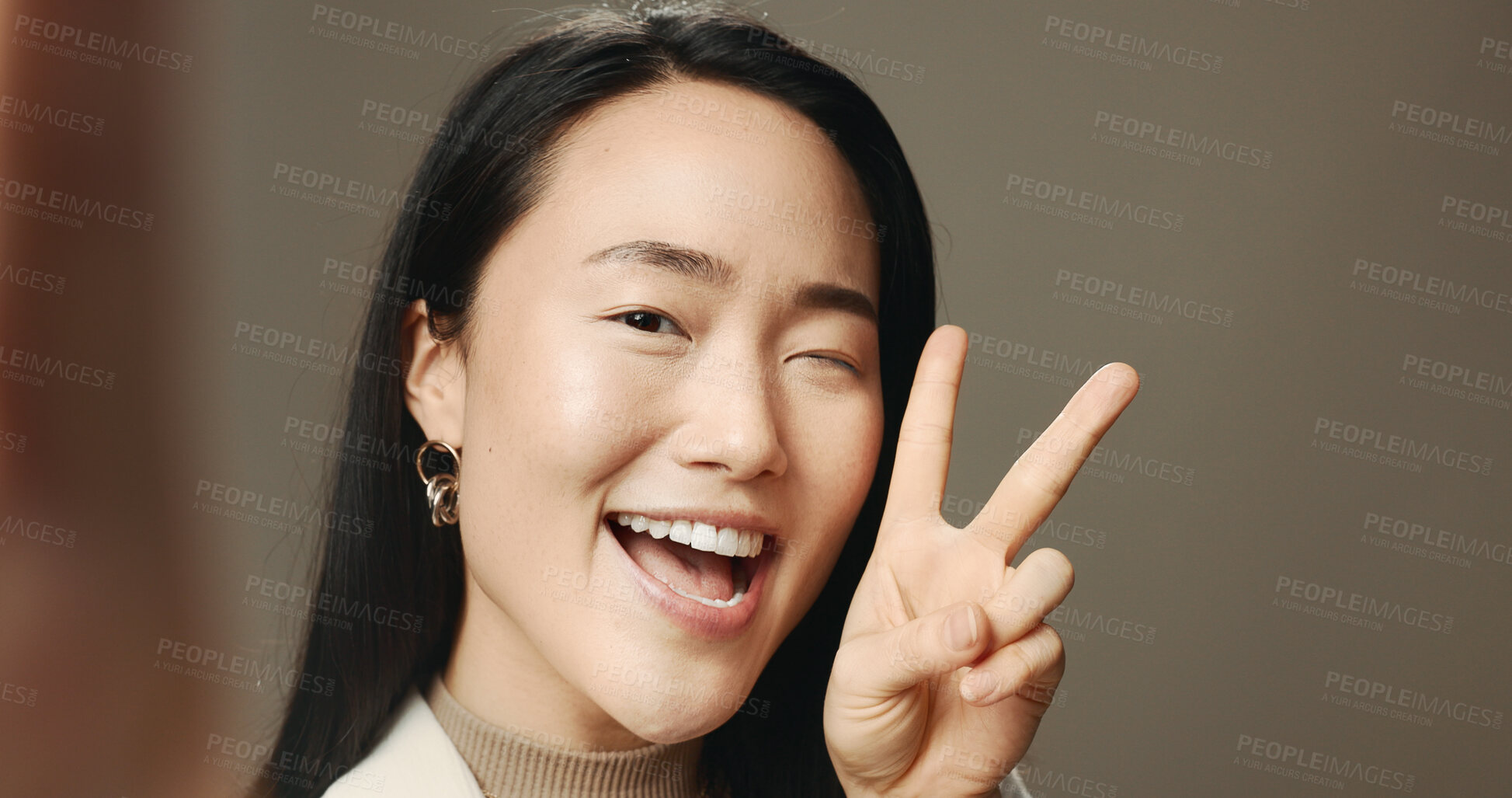 Buy stock photo Woman, wink and peace sign for selfie, happy and excited on studio background space. Asian person, v gesture and face portrait for pov photography, profile picture or hand emoji for social media post