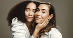 Women, friends and hug with beauty in studio for cosmetics, makeover and facial treatment. People, embrace and natural skin with inclusion, dermatology glow and glamour aesthetic on brown background