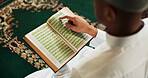 Muslim, man or Quran in temple for reading, studying or mindfulness with worship to praise Allah. Islamic person, religion or above with holy book for guidance, learning scripture or prayer in mosque