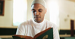 Islamic, man and Quran in mosque for reading, studying and spiritual help for worship or praise Allah. Muslim, faith or person with holy book for guidance, learning scripture and prayer in temple