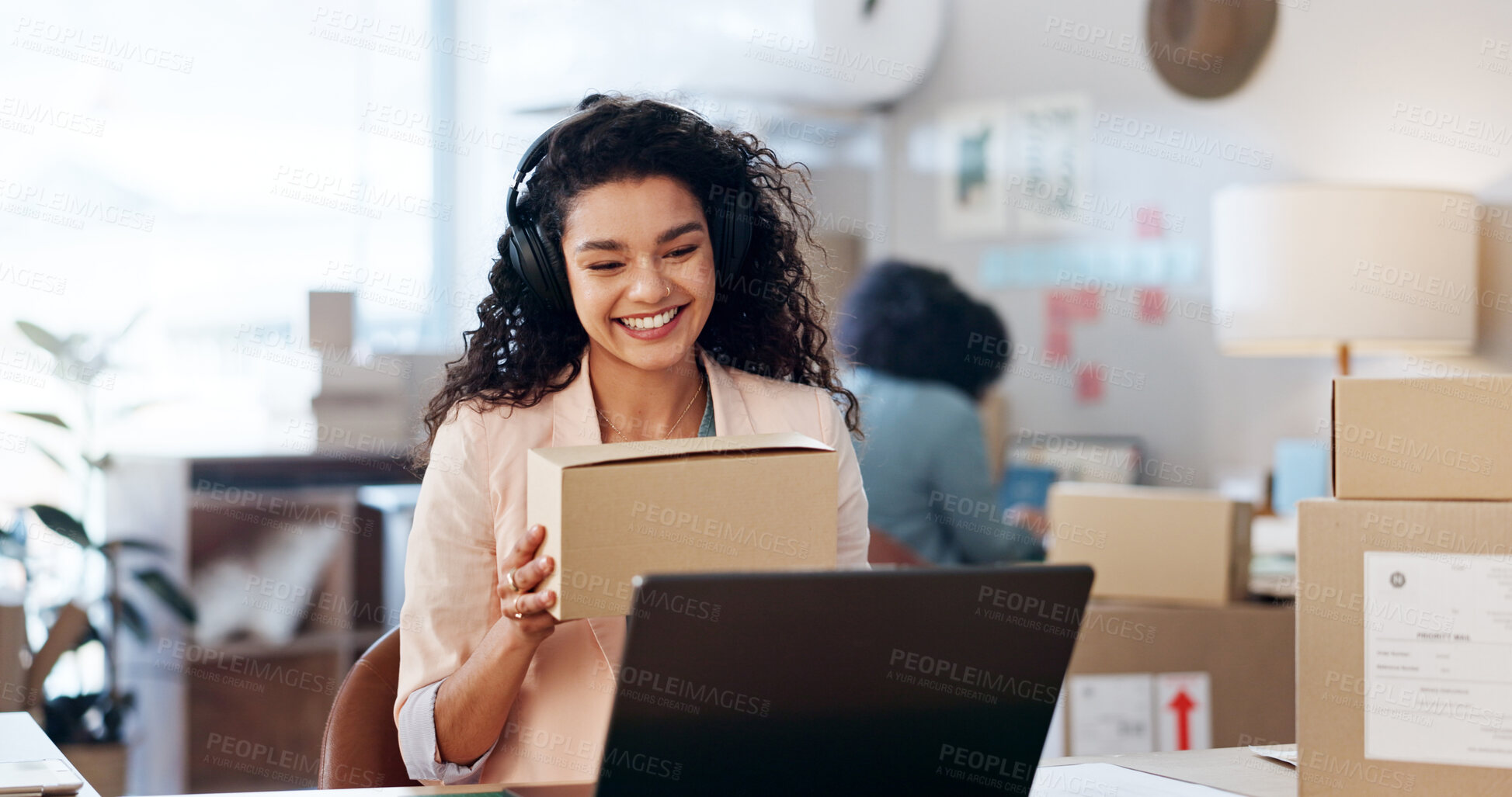 Buy stock photo Laptop, video call and woman with package in office for ecommerce, courier or confirmation. Computer, headphones and female designer with live streaming for sale promotion with cardboard boxes.