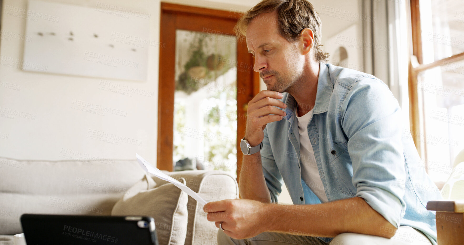 Buy stock photo Paperwork, thinking and man in home planning for debt, mortgage or tax payments in living room. Documents, digital technology and person with credit application, savings or monthly budget in house.