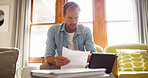 Documents, tablet and man in living room planning for debt, mortgage or tax payments in home. Paperwork, digital technology and male person with credit application, savings or monthly budget in house