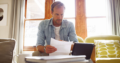 Buy stock photo Documents, tablet and man in living room planning for debt, mortgage or tax payments in home. Paperwork, digital technology and male person with credit application, savings or monthly budget in house