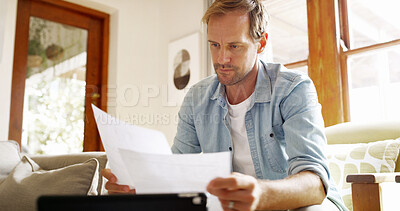 Buy stock photo Documents, reading and man in kitchen planning for debt, mortgage or tax payments in home. Paperwork, digital technology and male person with credit application, savings or monthly budget in house.