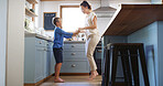 Home, mother and kid dancing in kitchen with holding hands, teaching steps or weekend break. Happy family, woman and boy with music for movement, learning and relationship with love, bonding or trust