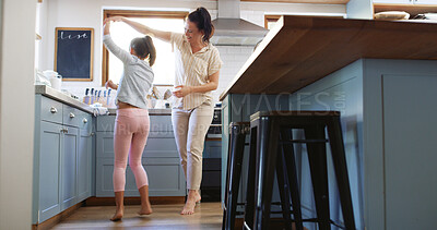 Buy stock photo Happy, mother and child dancing in kitchen with holding hands, spinning or teaching steps. Family, woman dancer or girl kid with music for movement, learning and relationship with love, care or trust