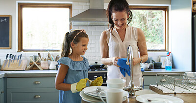Buy stock photo Mother, daughter and cleaning dishes for help, learning and bonding with chores in the home. Family, happy and mom with girl kid in kitchen wash dirty plates, teach maintenance and hygiene in house