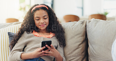 Buy stock photo Sofa, child and girl with smartphone for game, streaming online and watching video on social media. Home, female person and kid with mobile for application, digital reel and relax with smile on couch