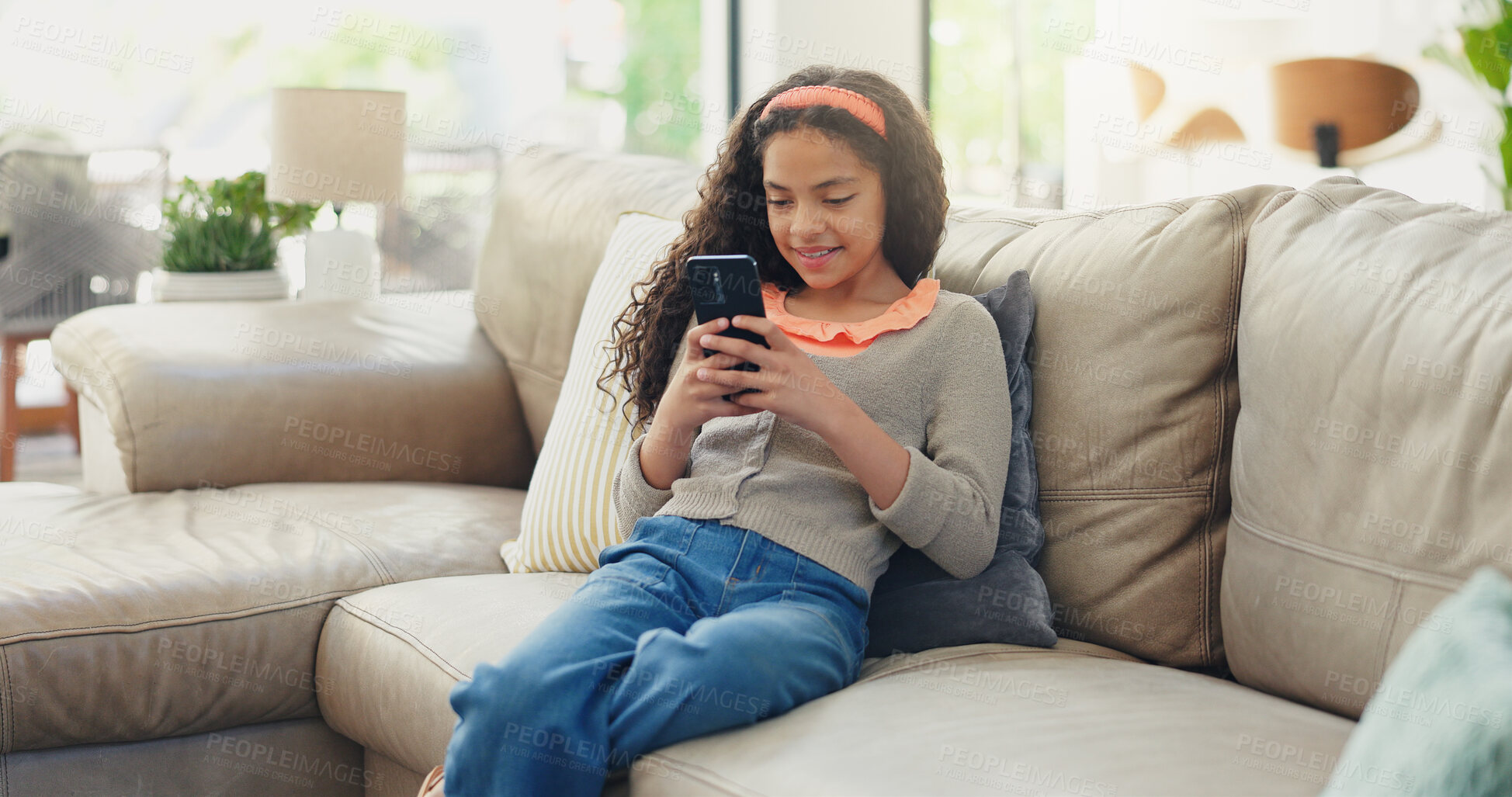 Buy stock photo Sofa, kid and girl with smartphone for game, streaming online and watching video on social media. Home, female person and child with mobile for application, digital reel and relax with smile on couch