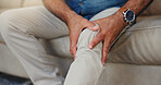 Senior, man and hands with knee pain on sofa for arthritis, muscle discomfort or osteoporosis. Closeup, elderly person or massage joint ache in home with tendinitis, ligament fracture or nerve damage