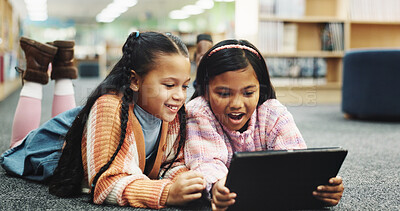 Buy stock photo Students, library and girls with tablet, surprise and online learning with education, smile and wow. Happy kids, shocked and friends on carpet, tech or storytelling with ebook and watching video