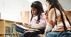 Girl, together and reading with story at library for development, learning and study with literature. School kids, book and help with scholarship, education and language with knowledge at academy