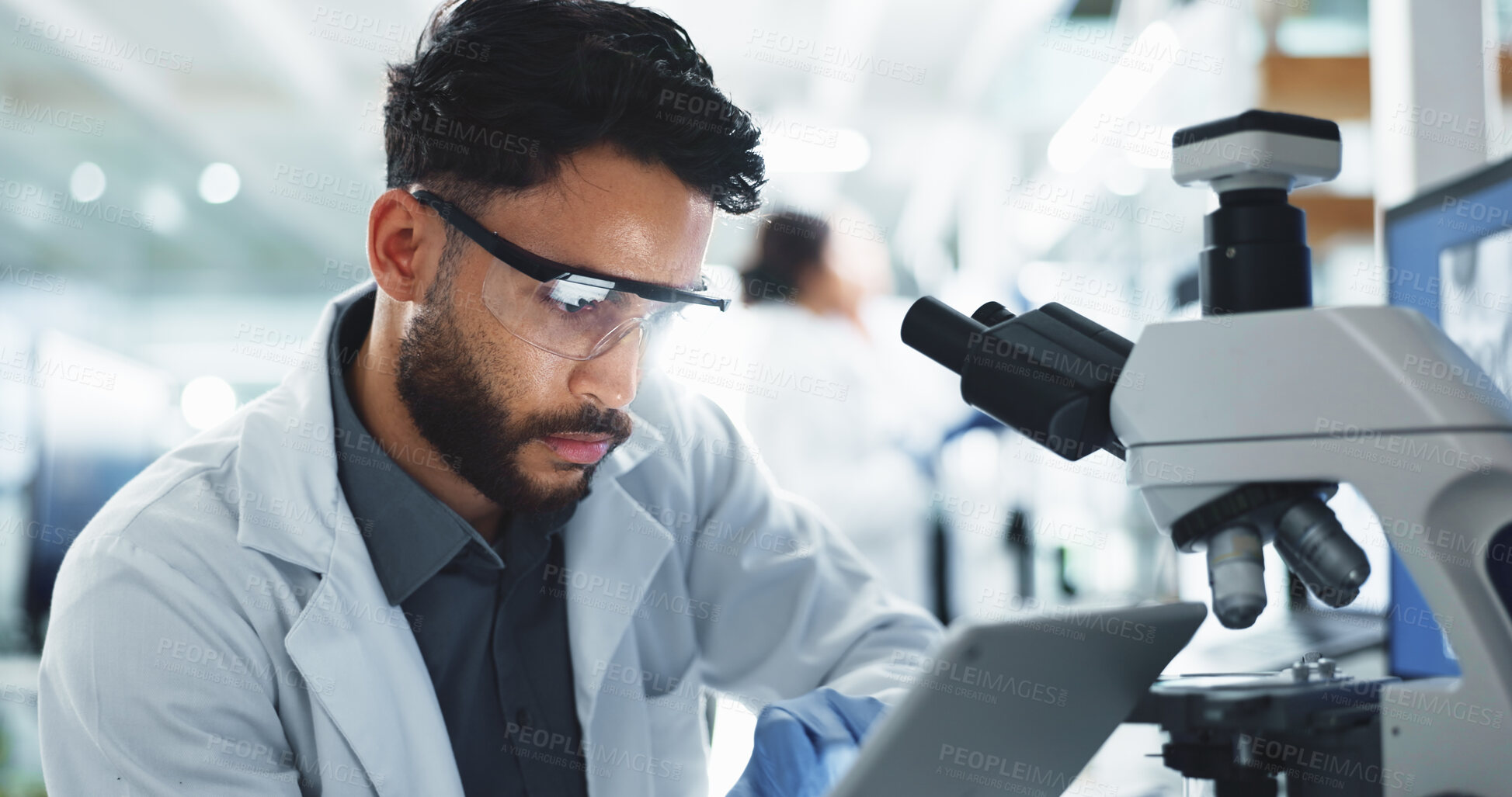 Buy stock photo Tablet, man and scientist with microscope in laboratory for online research with DNA for medical innovation. Biotechnology, goggles and male biologist with RNA for pharmaceutical study or discovery.