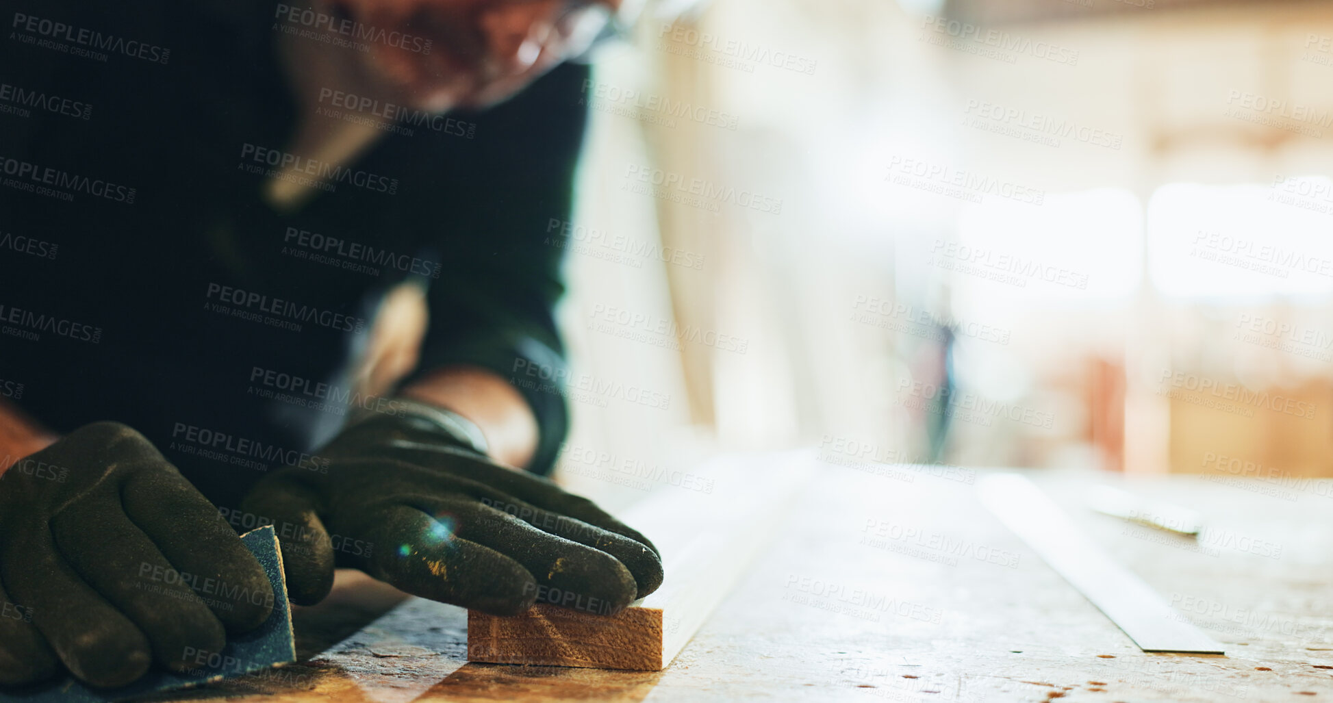 Buy stock photo Carpenter, woodworking and man with sandpaper, hands and smoothing surface with tool or manufacturing. Production, artisan and person with gloves for safety, grip and shaping of material in business