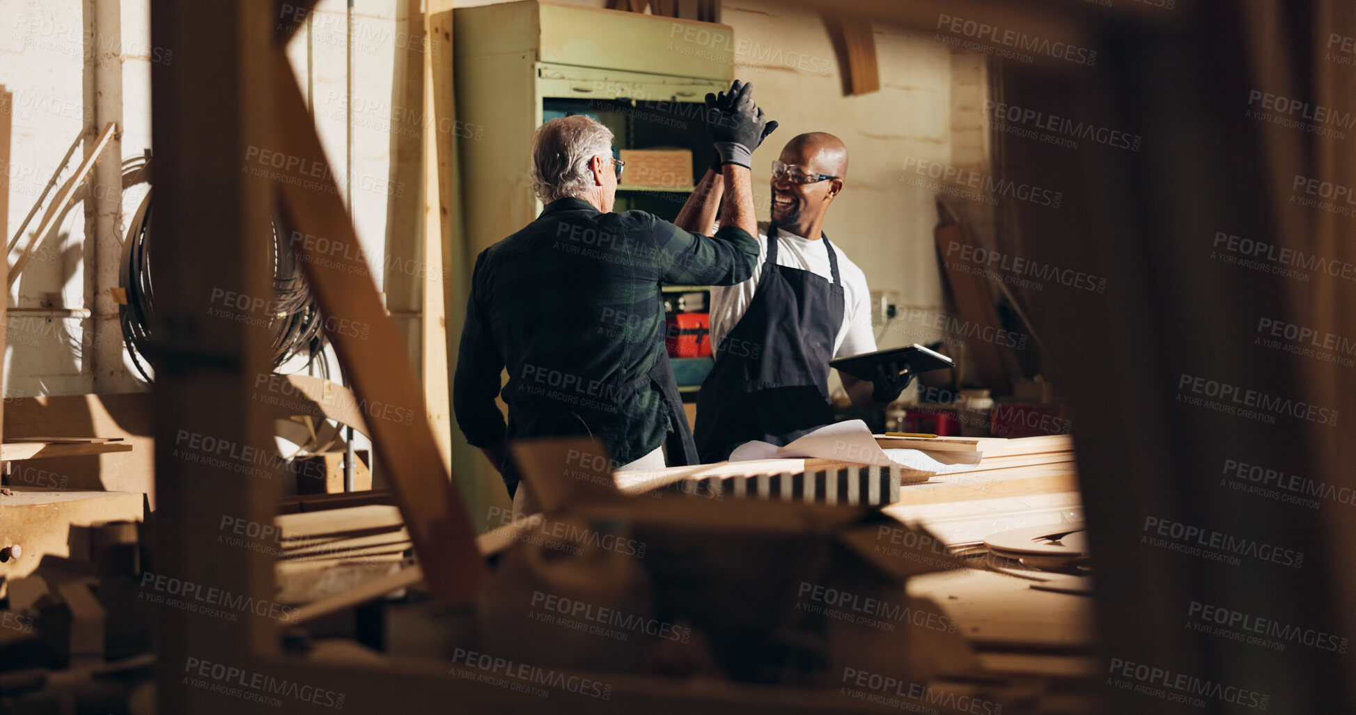Buy stock photo Carpenter, men and high five for work, skills and helping intern with tablet, woodwork and material. Warehouse, mature mentor and trainee with happy for craftsmanship, people or celebration for sales