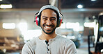 Carpenter, man and portrait with headphones in workshop for woodwork, furniture production or hearing protection. Manufacturing industry, worker and happy in warehouse for carpentry or small business