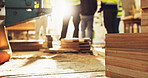 Wood, carpentry and material on floor at warehouse with engineer group in meeting for construction planning. People,  carpenter and legs in team with manufacturing, production and industry at factory