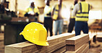 Wood, carpentry and helmet for safety at warehouse with engineer group in meeting for construction planning. People,  carpenter and ppe in team with manufacturing, production and industry at factory