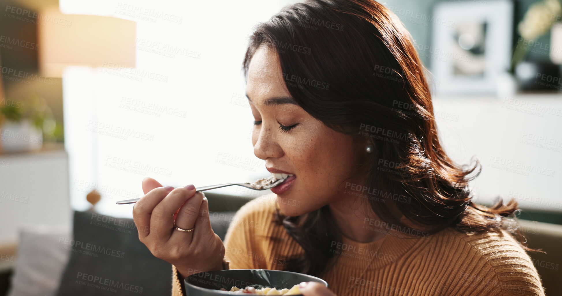 Buy stock photo Home, woman and eating food on sofa for healthy meal, nutrition or enjoyment with eyes closed. Dinner, person and hungry with pasta bowl in living room for lunch diet, satisfaction or flavor in house