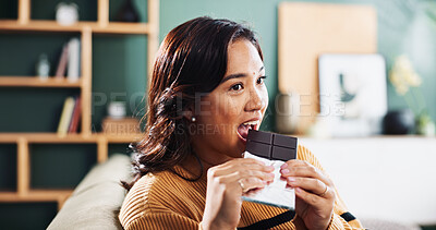 Buy stock photo Biting, chocolate and woman with snack, home and relax in living room with tasty treat or junk food. Break, joy and enjoying candy in lounge, sugar and nutrition in dessert, eating or person in house