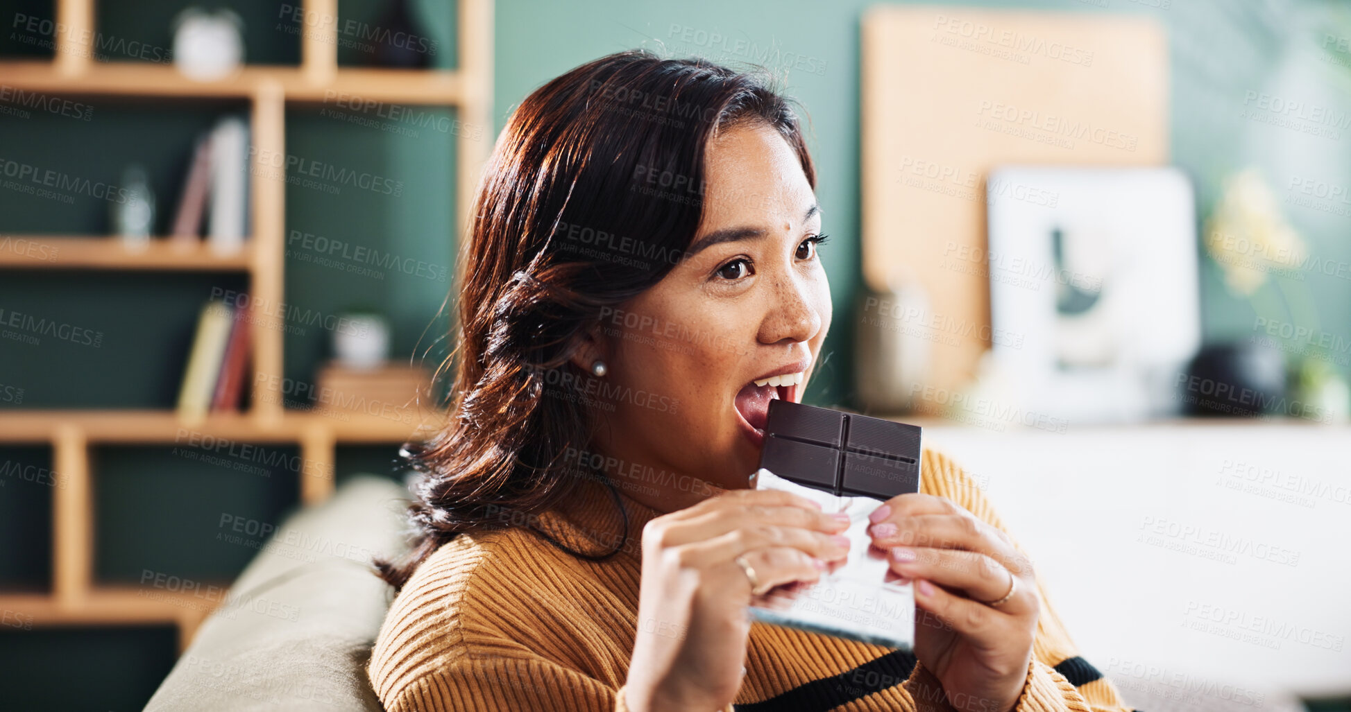 Buy stock photo Biting, chocolate and woman with snack, home and relax in living room with tasty treat or junk food. Break, joy and enjoying candy in lounge, sugar and nutrition in dessert, eating or person in house