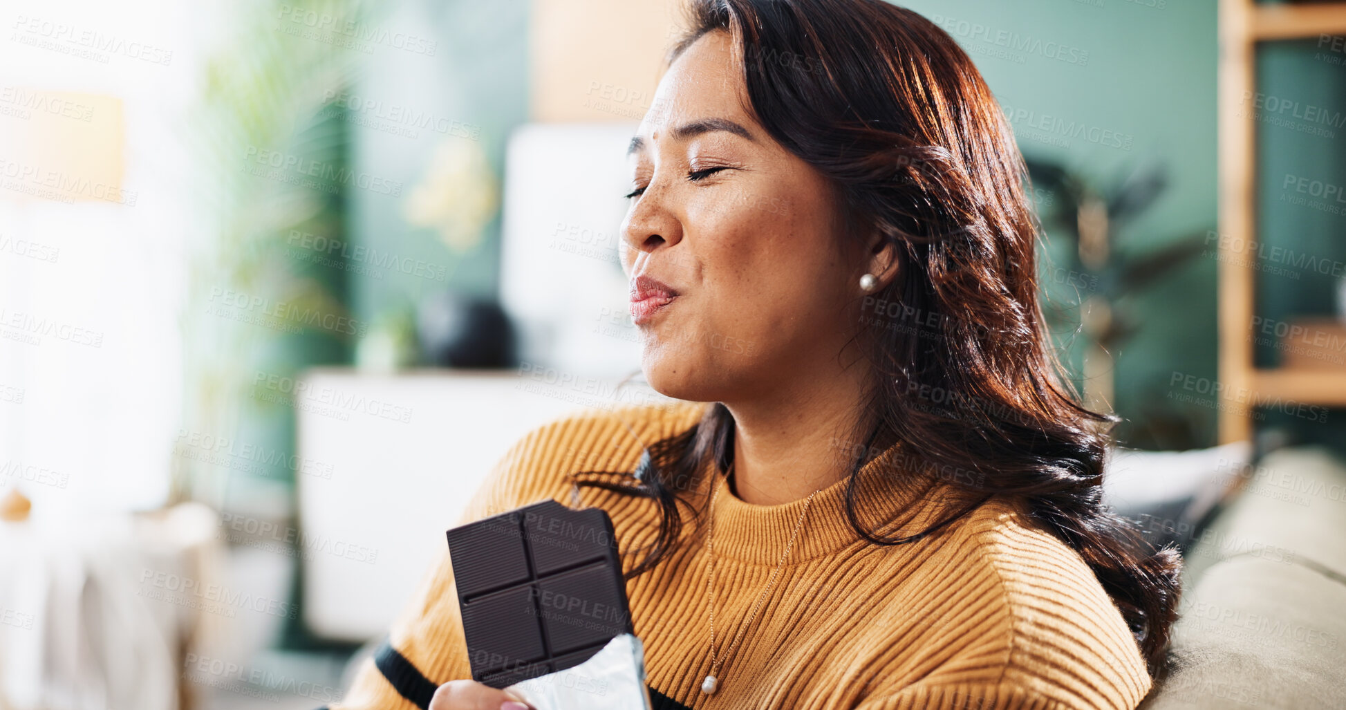Buy stock photo Enjoying, chocolate and woman with snack, home and relax in living room with tasty treat and junk food. Break, person and smile for candy in lounge, sugar and nutrition in dessert, eating and house