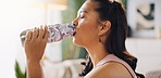 Woman, drinking and water with bottle in fitness for hydration, workout or exercise at home. Female person, thirsty or refreshment with mineral liquid for natural sustainability or diet at house