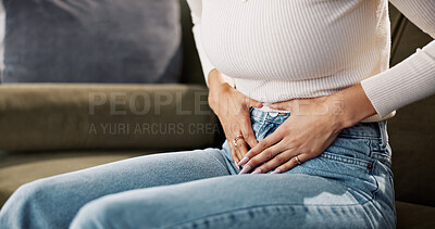 Buy stock photo Home, woman and hands on tummy for pain, menstrual cycle and endometriosis on sofa in living room. House, female person and closeup with stomach ache for constipation, gastro crisis and period cramps
