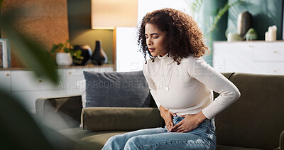 Buy stock photo Sofa, woman and hands on stomach for pain, menstrual cycle and endometriosis in living room at home. House, female person and closeup with abdomen ache for constipation, gastro crisis or period cramp