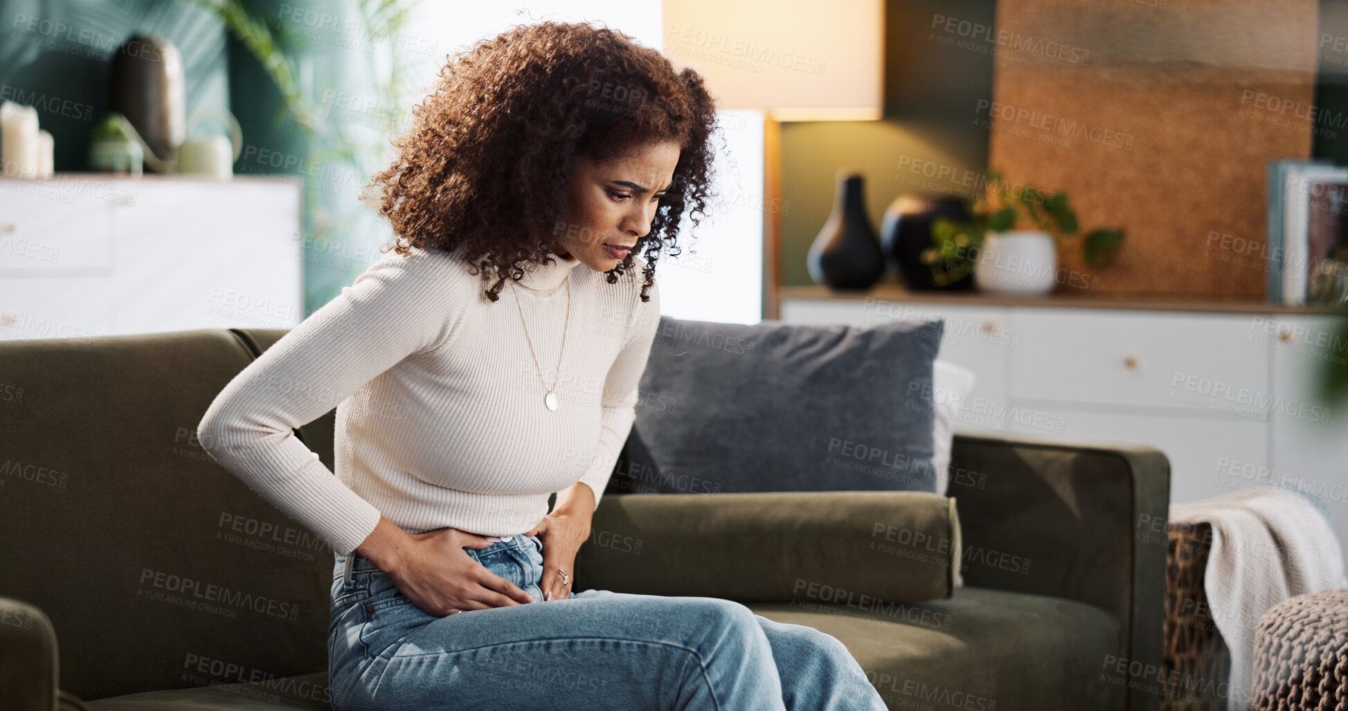 Buy stock photo Couch, woman and hands on stomach for pain, menstrual cycle or endometriosis in lounge at home. House, female person or sick with abdomen ache for constipation, gastro crisis or period cramps on sofa