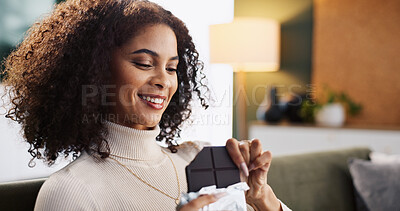 Buy stock photo Smile, woman and eating dark chocolate in home, candy and hungry for comfort food with sugar snack. Living room, sweets and African person with cacao bar for treats, confectionery and enjoy dessert