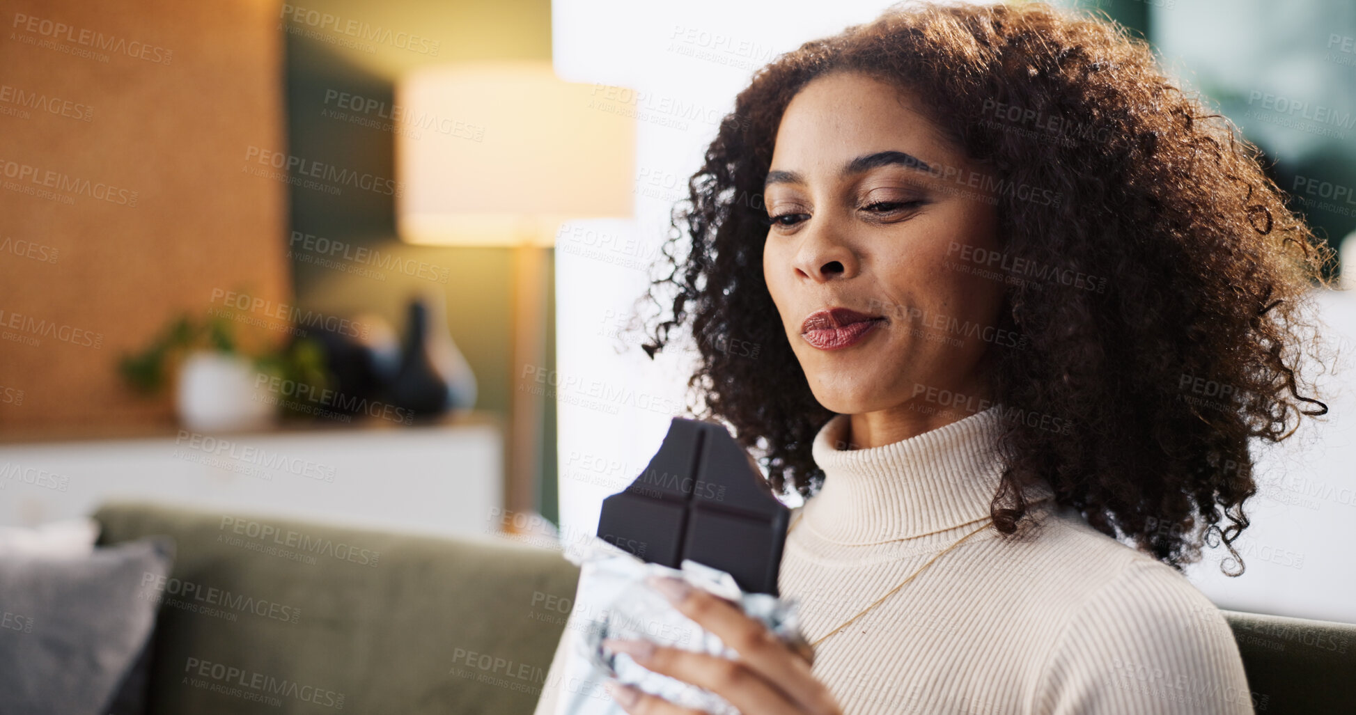 Buy stock photo Relax, woman and eating dark chocolate in home, candy and hungry for comfort food with sugar snack. Living room, sweets and African person with cacao bar for treats, confectionery and enjoy dessert