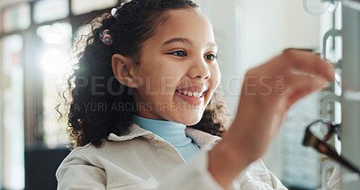Buy stock photo Optometry, kid and girl with glasses, excited and new frame with decision, wellness and medical service. Prescription, clear vision or child with eyewear, support or healthcare with lenses or smile