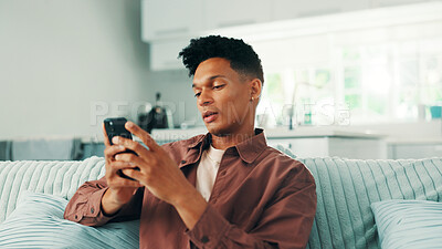 Buy stock photo Dating app, phone and man texting in home on social media application and subscription on weekend. Chilling, technology or male person with mobile message on sofa for post, chat and online website