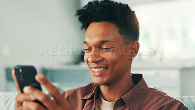 Buy stock photo Funny, phone and man with smile in home on social media application and texting on weekend. Chilling, meme or happy person laughing at mobile message on sofa for comedy post, chat or dating website