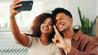 Buy stock photo Peace sign, selfie and smile with couple on sofa in living room of home together for memories. Love, photograph and relax with happy people in apartment for social media or profile picture update