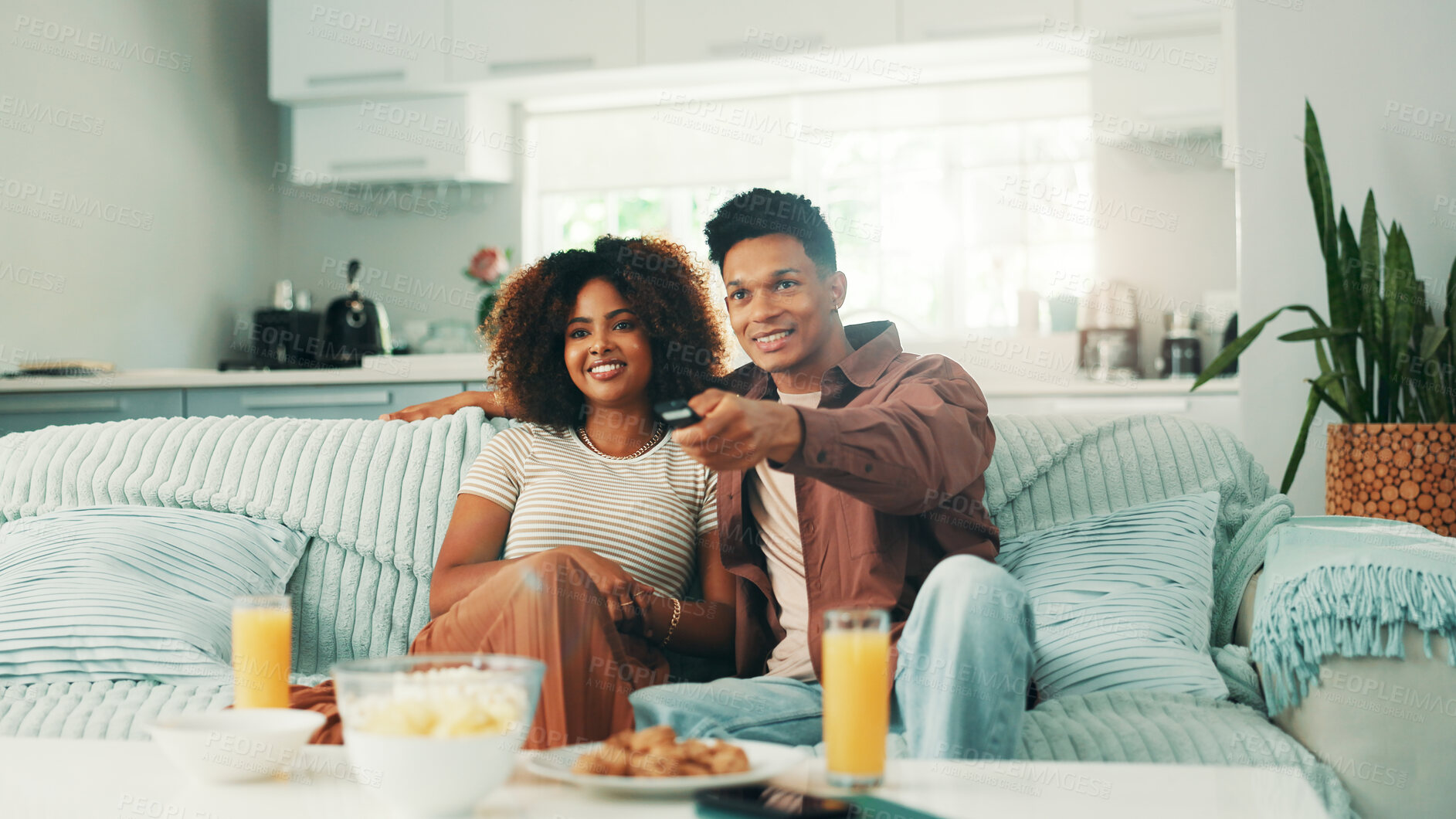 Buy stock photo Couple, watching tv and remote at home with movies, series and browsing online. Man, woman and living room sofa for bonding, press play or snacks with subscription package for entertainment in house