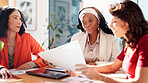 Women, meeting and paperwork with team at startup, brainstorming and review with problem solving at office. Business people, documents and group with report, proposal and feedback at creative agency