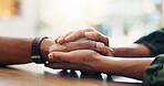 Care, support and couple holding hands for love, loyalty and connection in home on table. Comfort, kindness and people closeup for empathy, forgive partner and commitment for relationship together
