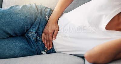 Buy stock photo Woman, relax or hands on tummy with pain, menstruation cramps or IBS symptoms in home. Person, discomfort or rest on sofa with period, stomach ache or bloating with celiac complication in living room
